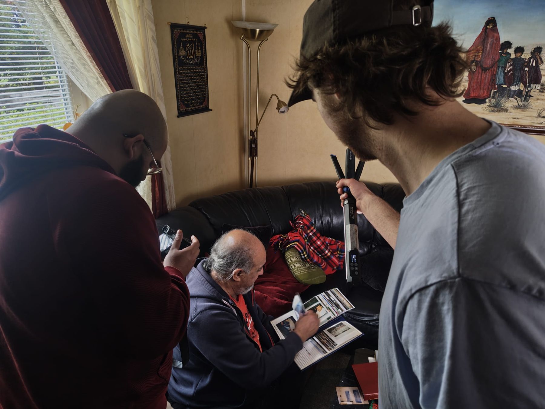 Teamet ljussätter Walid med en tube light medan han bläddrar i ett fotoalbum